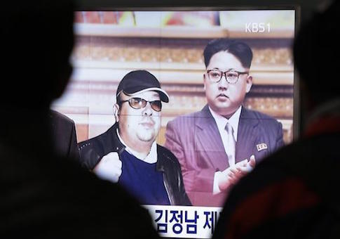 A TV screen shows pictures of North Korean leader Kim Jong Un and his older brother Kim Jong Nam