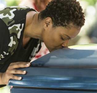 Maj. Jaspen Boothe, president of the non-profit Final Salute Incorporated, kisses the casket of World War II veteran Serina Vine after the funeral service / AP