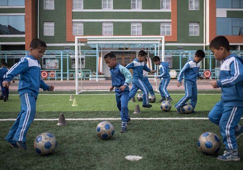 Children play football during a visit organized for visiting foreign journalists at a school for orphans on the outskirts of Pyongyang / Getty Images
