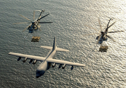 Two U.S. Marine Corps CH-53E Super Stallion helicopters receive fuel from a KC-130 Hercules over the Gulf of Aden