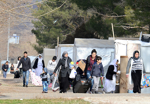 Yazidis refugees carry their belongings in Diyarbakir, southeastern Turkey as they change their refugee camp