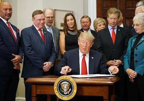 President Donald Trump signs an executive order on health insurance