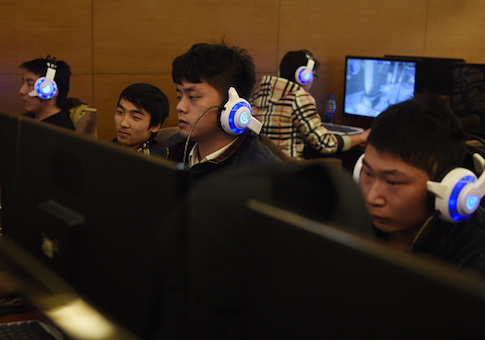 Men look at computers in an internet bar in Beijing