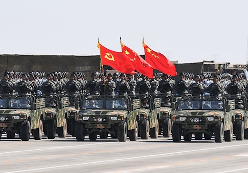 Chinese soldiers carry the flags of the Communist Party, the state, and the People's Liberation Army during a military parade