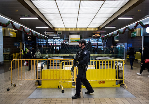 A member of the New York City Police Department stands guard inside the New York Port Authority Bus Terminal after it reopened following an explosion