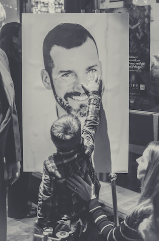 James Hanson touches the photo of his father, J.J., as wife Kris looks on 