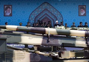 An Iranian medium range missile Zelzal passes by Iranian President Hassan Rouhani during the annual military parade