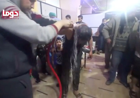 A man is washed following alleged chemical weapons attack, in what is said to be Douma