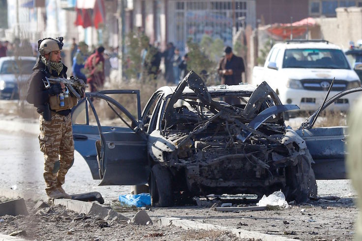 A soldier stands next to the site of an unrelated terror attack