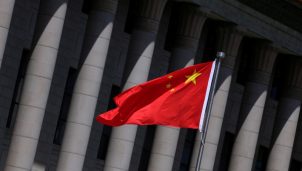 Chinese flag flutters in front of the Great Hall of the People in Beijing