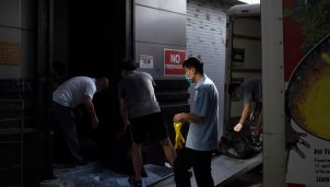 People move trash bags from the Chinese consulate in Houston on July 24