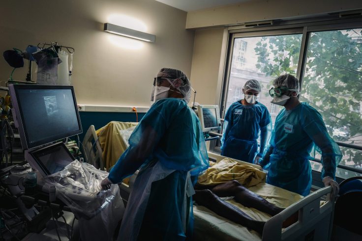 Medical staff members transport a patient infected with coronavirus at the intensive care unit of the Lariboisiere Hospital in Pari