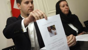 Daniel Levinson (L) shows a picture of his father, ex-FBI agent Robert Levinson during a press conference