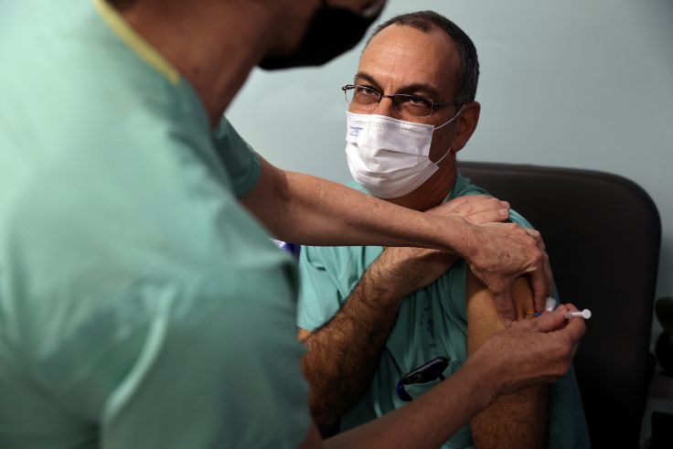 Doctor Guy Choshen, director of the COVID-19 ward in Ichilov Hospital, gets his second vaccination injection against coronavirus disease in Tel Aviv