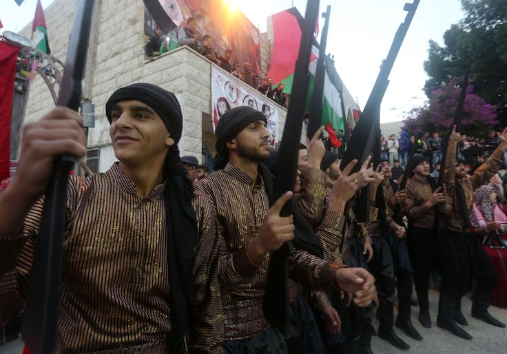 Palestinians take part in a party on the occasion of the 49th anniversary of the creation of the Popular Front for the Liberation of Palestine